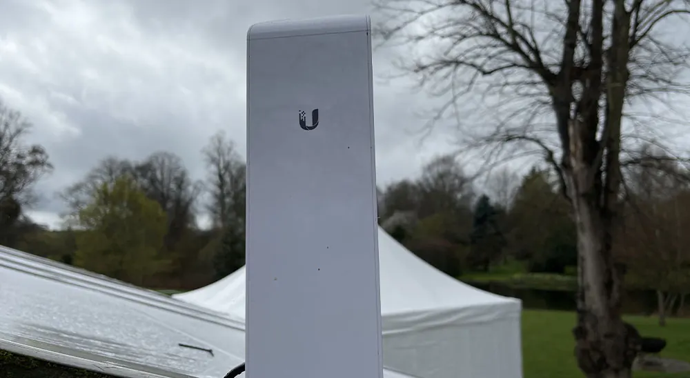 Outdoor wireless access point mounted on a pole near a garden marquee
